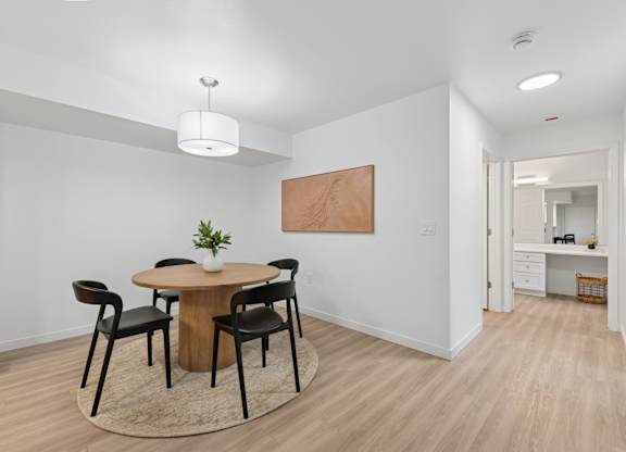 A dining room with a round table and chairs.