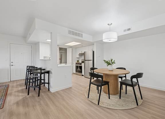 A dining room with a round table and chairs.