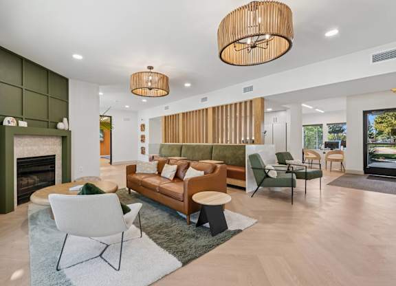 A modern living room with a fireplace and a green couch.