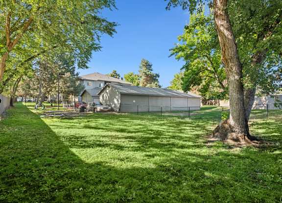 A house with a fence and trees in front of it.