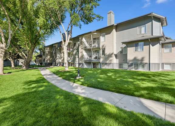 Apartment complex with a walkway in front.