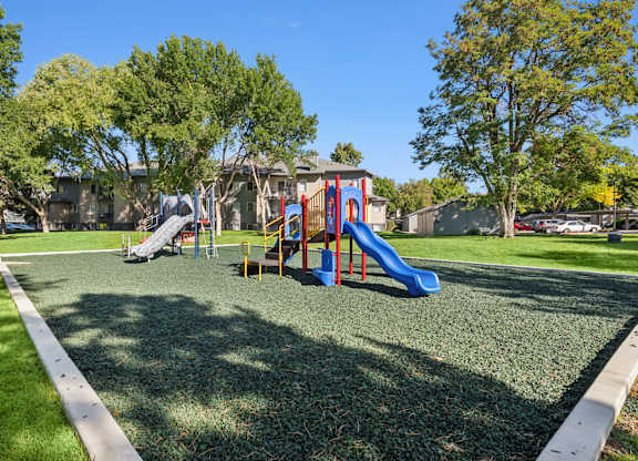 A playground with a blue slide and a red and yellow slide.