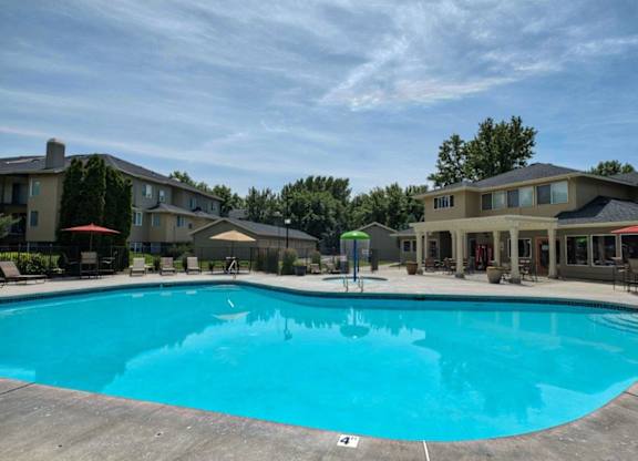 A large swimming pool in front of apartment buildings.