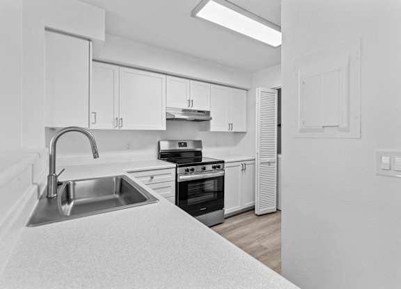 A kitchen with white cabinets and appliances.
