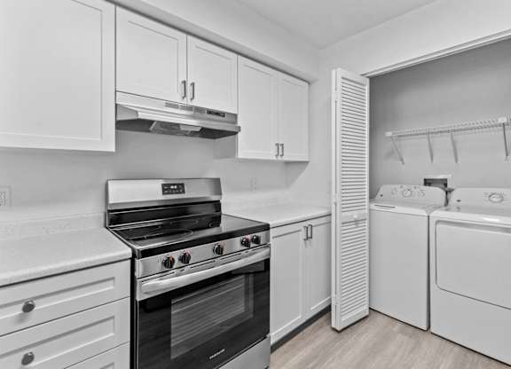 A modern kitchen with white cabinets and appliances.