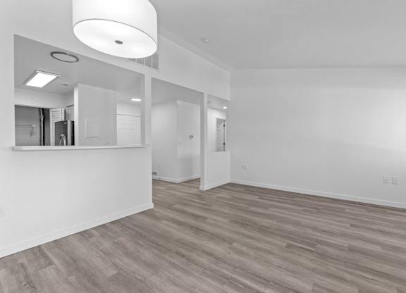 A room with a white ceiling and wooden flooring.
