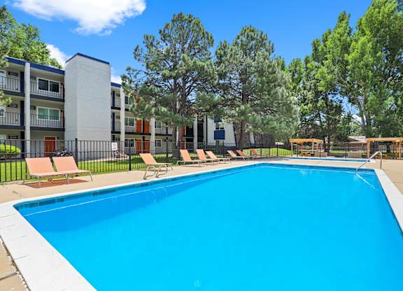 A swimming pool in front of apartment buildings.