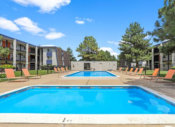 A large swimming pool in front of apartment buildings.