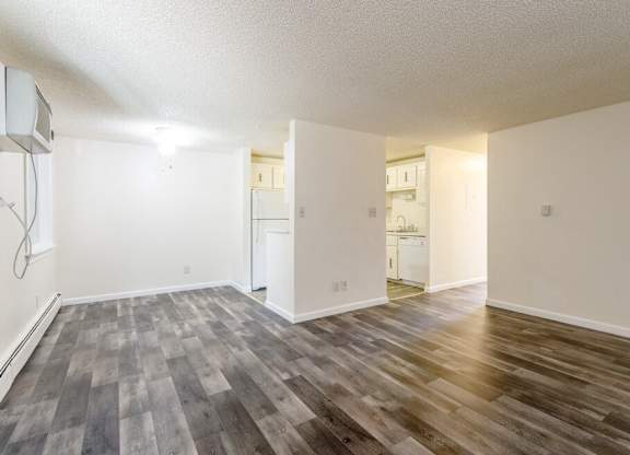 A room with wooden flooring and white walls.