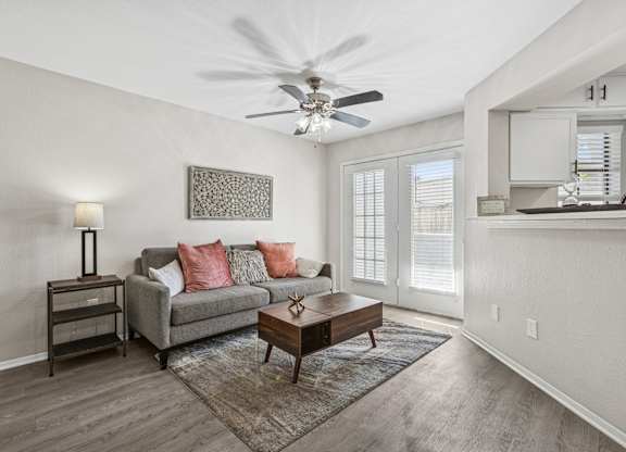 Living room with ceiling fan and patio access at Polo Club Apartments, Austin, Texas