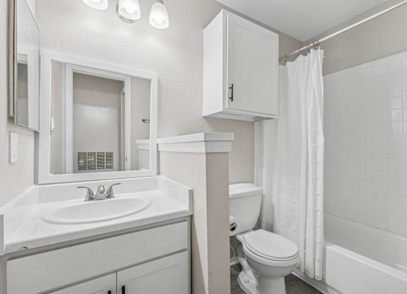 Modern bathroom with white fixtures and tile at Polo Club Apartments, Austin