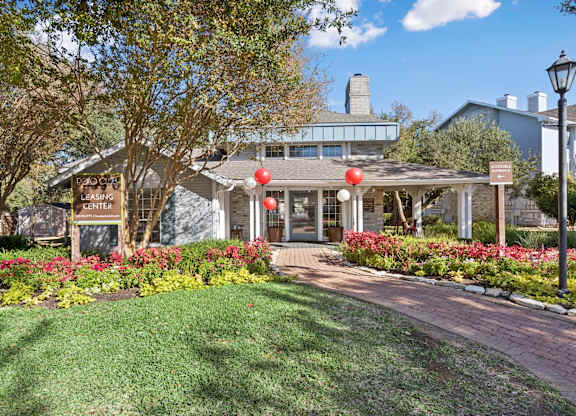 Leasing center with brick walkway and flowers at Polo Club Apartments, Austin, TX