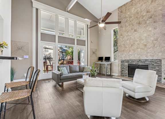 Spacious living room with fireplace and tall windows at Polo Club Apartments, Austin, 78729