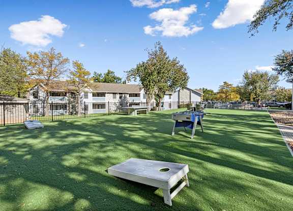Outdoor recreation area with cornhole and lawn games at Polo Club Apartments, Texas