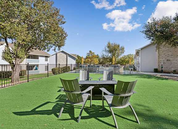 Outdoor seating area with fire pit on artificial turf at Polo Club Apartments, Texas, 78729