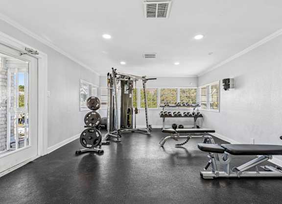 Fitness center with weight equipment and workout benches at Polo Club Apartments, Austin, 78729