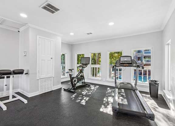 Home fitness room with cardio equipment and pool views at Polo Club Apartments, Austin, TX 78729