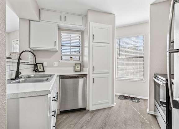 Small kitchen with white cabinets and stainless steel appliances at Polo Club Apartments, Austin, 78729