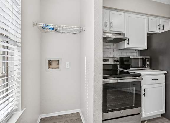 Laundry alcove with wire shelving beside kitchen area at Polo Club Apartments, Texas, 78729