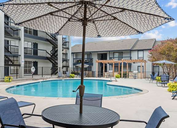 Resort style pool deck with pergola and lounge chairs at Peaks at Live Oak Apartments, San Antonio