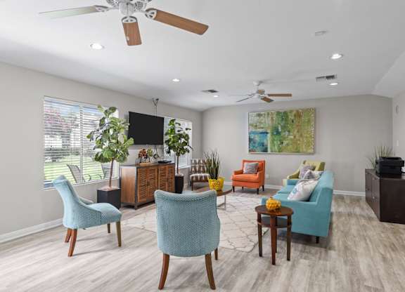 Community lounge with colorful seating and ceiling fans at Peaks at Universal City Apartments, Texas, 78148