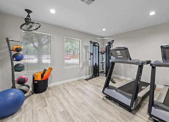 Fitness center with treadmills and weight machines at Peaks at Universal City Apartments, Universal City, Texas