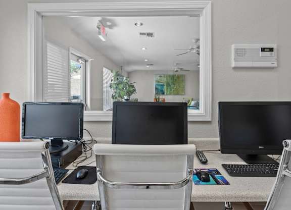 Office workspace with multiple computer stations at Peaks at Universal City Apartments, Texas