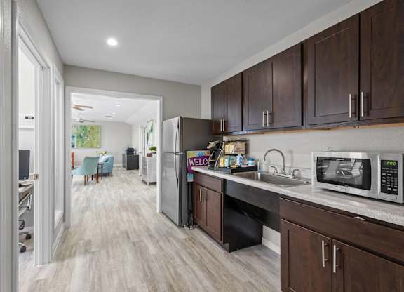 Modern kitchen with stainless steel appliances and dark wood cabinetry at Peaks at Universal City Apartments, Universal City, TX 78148