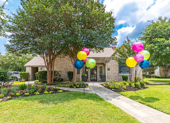Community leasing office entrance with festive balloon display at Peaks at Universal City Apartments, Universal City, TX 78148