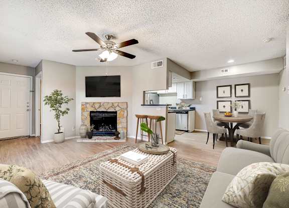 Open concept living room with stone fireplace and kitchen at Peaks at Universal City Apartments, Universal City, 78148