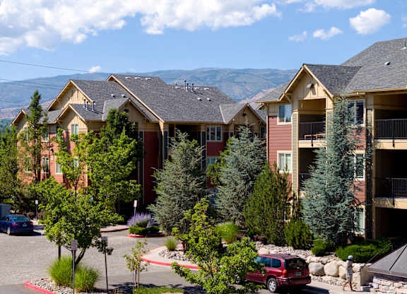 A row of houses with trees in front of them.