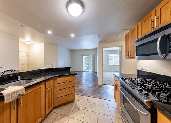 A kitchen with wooden cabinets and a black stove top.
