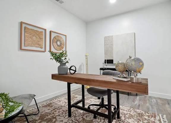 A room with a wooden table, a chair, and a rug.