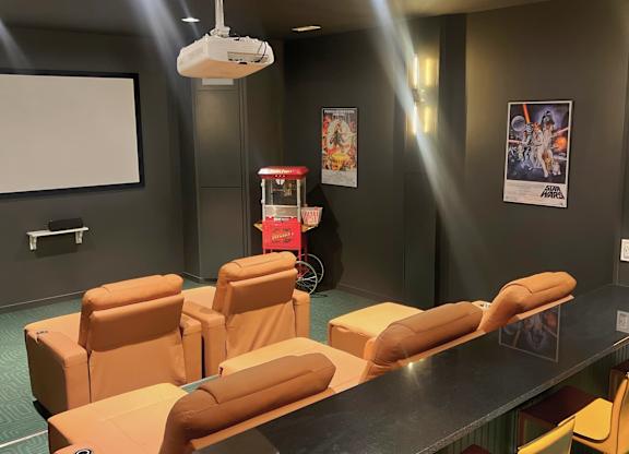 A room with a long table and chairs, a projector, and posters on the wall.