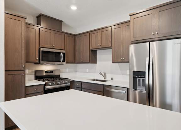 A Kitchen with Brown Cabinets at Montessa Apartments, California