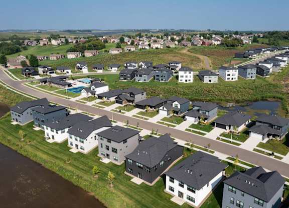 A row of houses with a body of water in front of them.