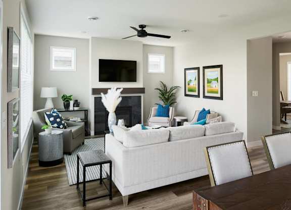 A living room with a white couch, a fireplace, and a television.