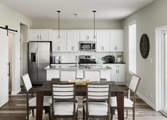 A modern kitchen with a dining table and chairs.