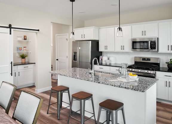 A modern kitchen with white cabinets and a granite countertop.