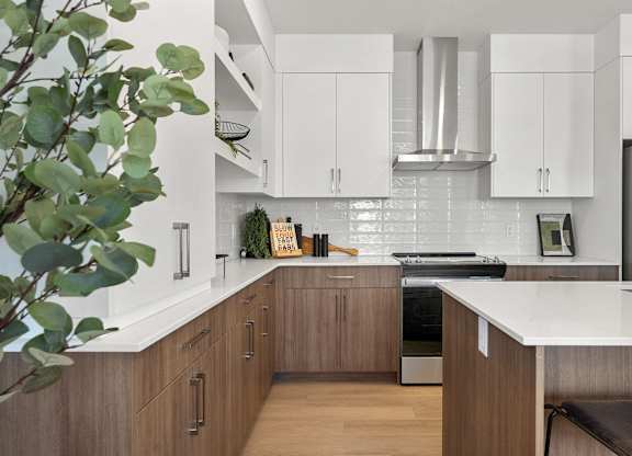 A modern kitchen with wooden cabinets and a stainless steel refrigerator.