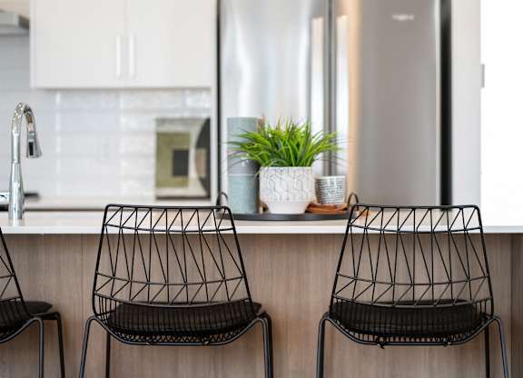 Two black chairs are placed in front of a kitchen counter.