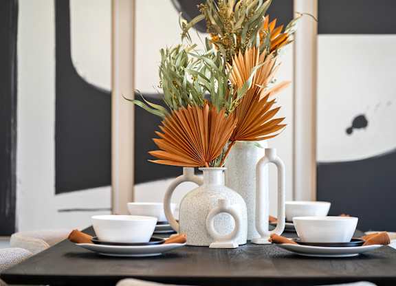 A table setting with a white vase and bowls.