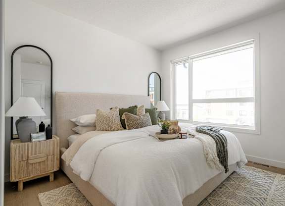 A bedroom with a large bed and a wooden nightstand.