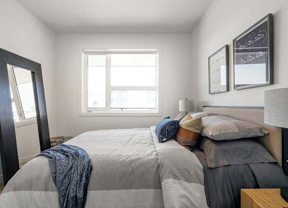 A bedroom with a large bed and a window.