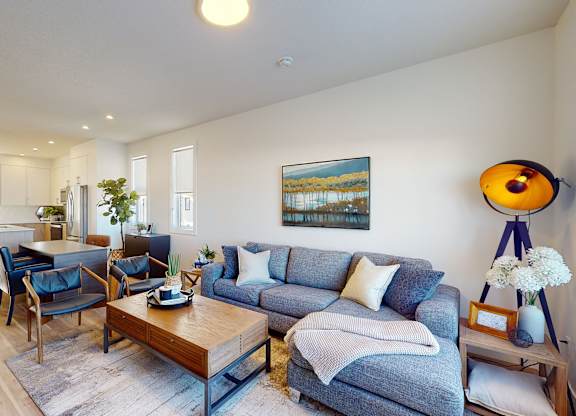 A living room with a grey couch and a wooden coffee table.