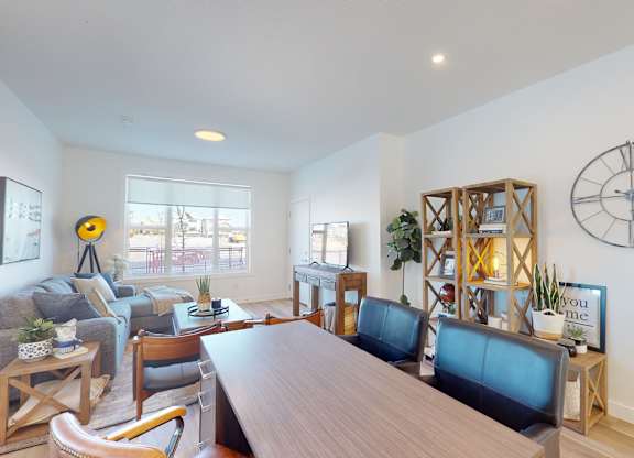 A living room with a long wooden table and blue chairs.