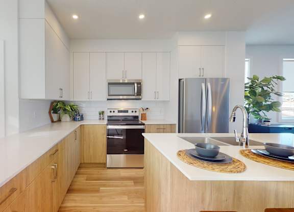 A modern kitchen with wooden cabinets and stainless steel appliances.