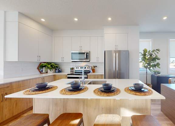 A modern kitchen with a dining table set for four.