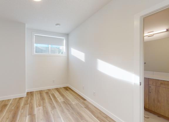 A room with wooden flooring and a window.