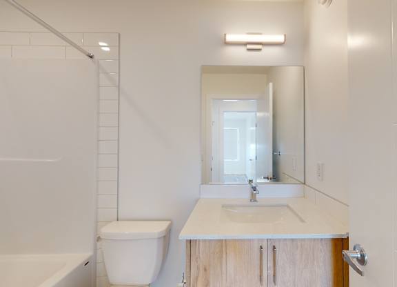 A white bathroom with a toilet, sink, and bathtub.